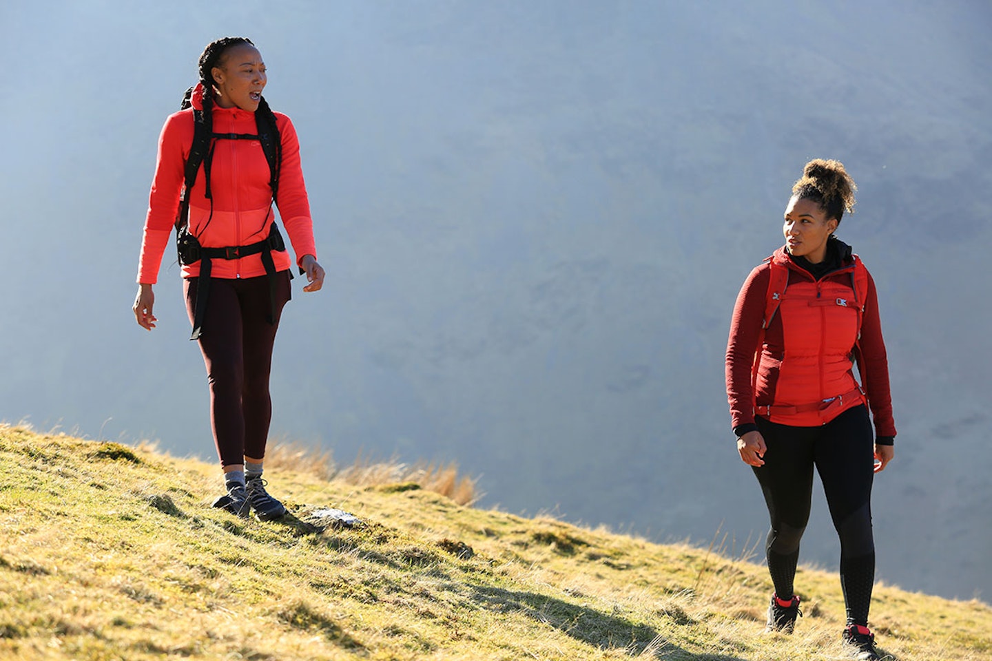 Two women wearing red mid layers while walking in the Lake District