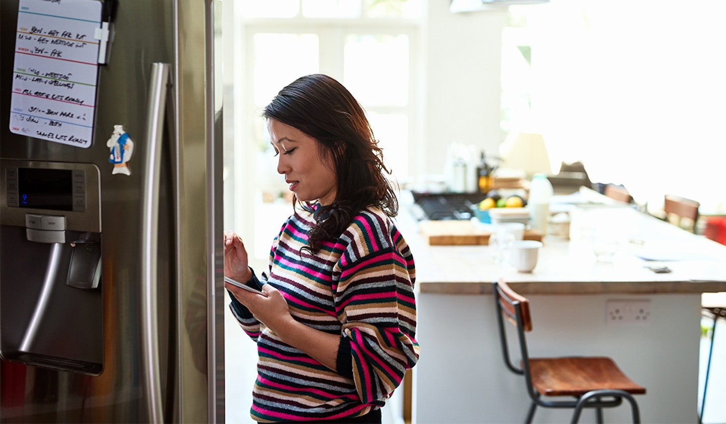 woman taking stock of fridge