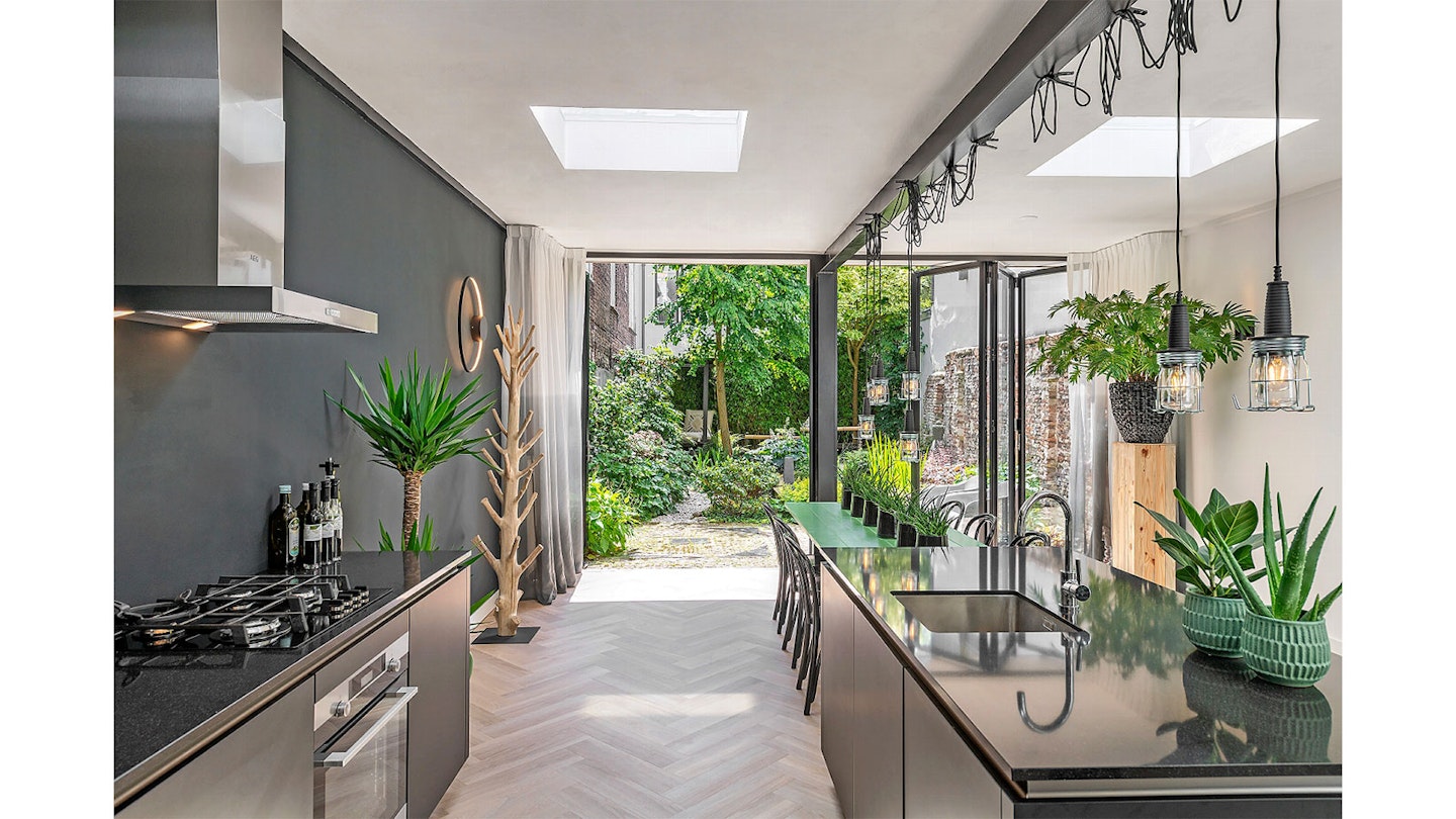stylish kitchen with bifold doors opening into modern garden
