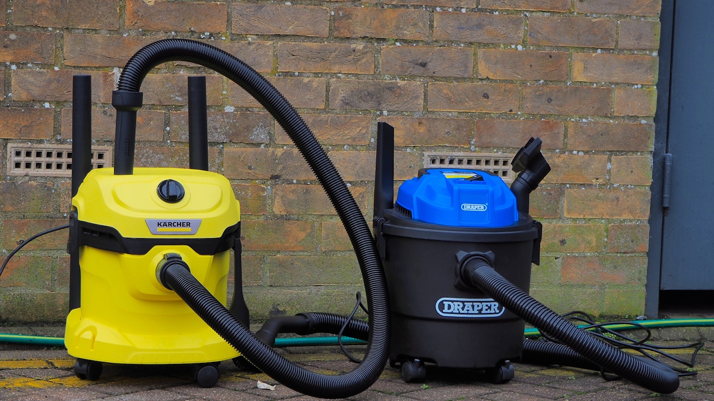 Karcher and Draper vacuums in front of a brick wall 