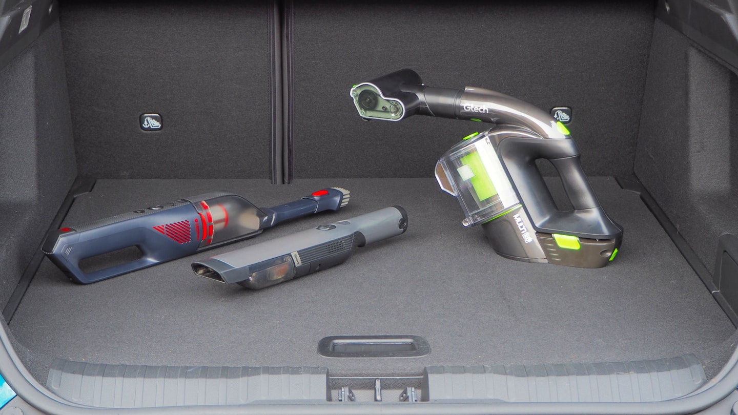 Eufy, Shark, and Gtech vacuums displayed in a car boot