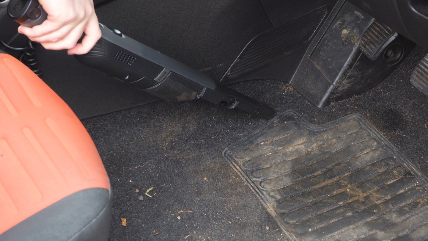 Shark vacuum cleaning a car footwell