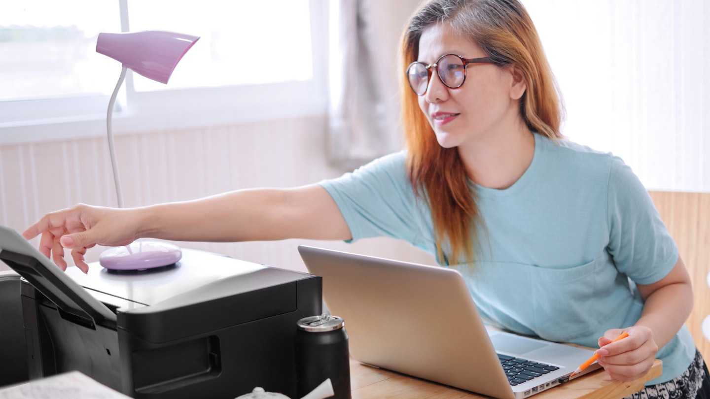 An image of a woman using a printer
