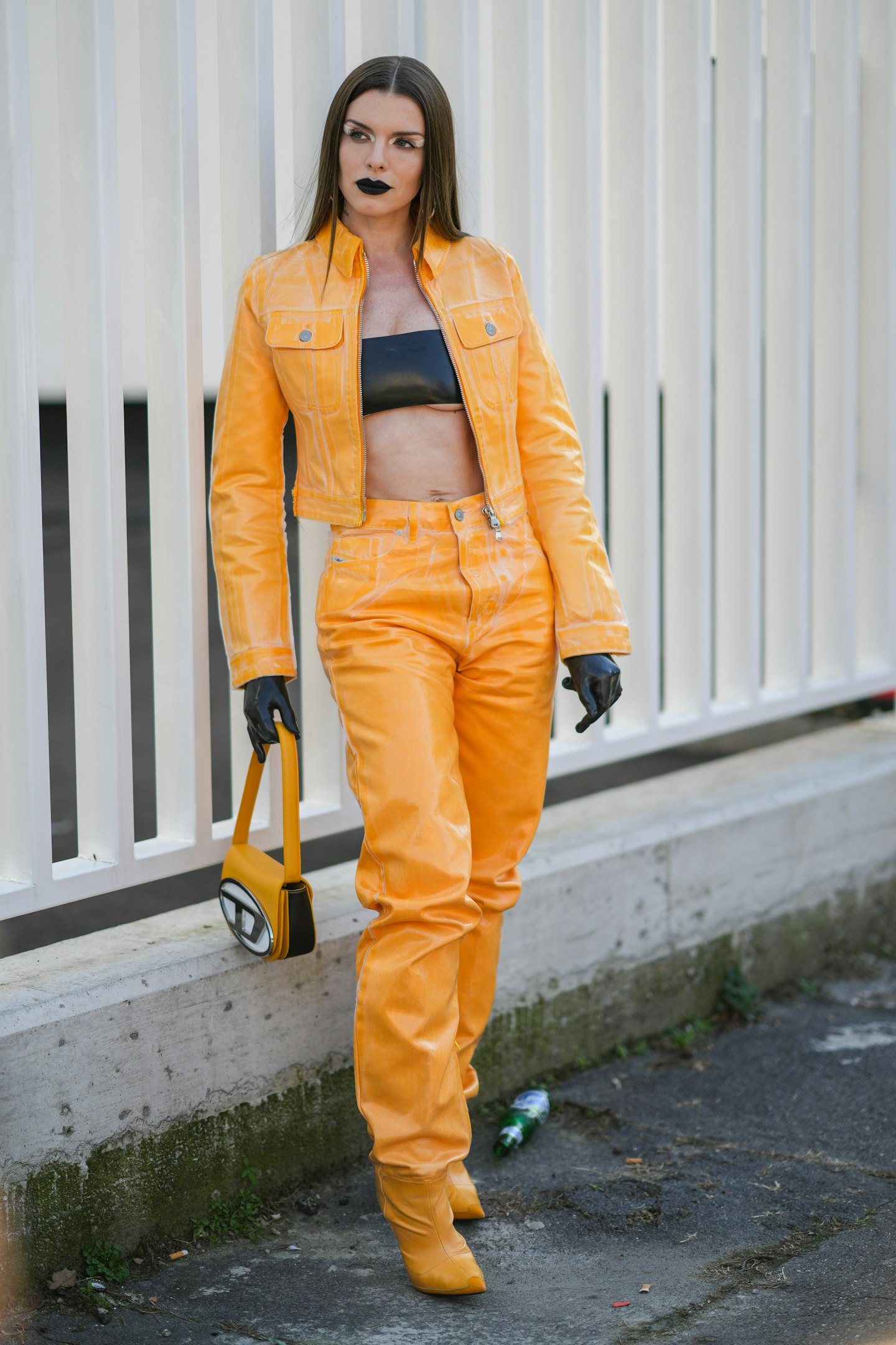 A guest wears a yellow shiny leather jacket, black shorts, a brown LV  News Photo - Getty Images