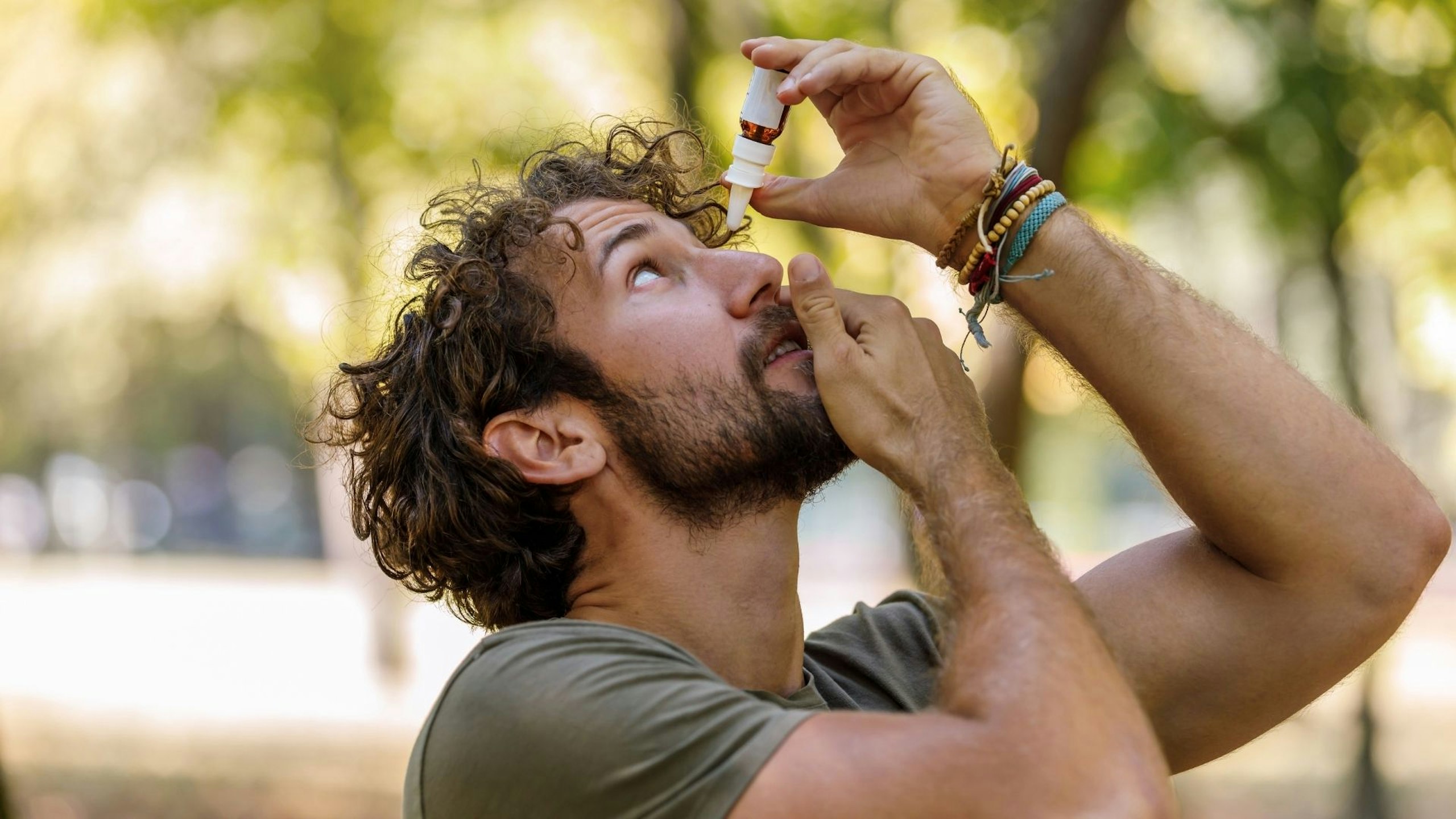 A Mature Man with Eye Problems is Applying Eye Drops in Nature - best hay fever eye drops
