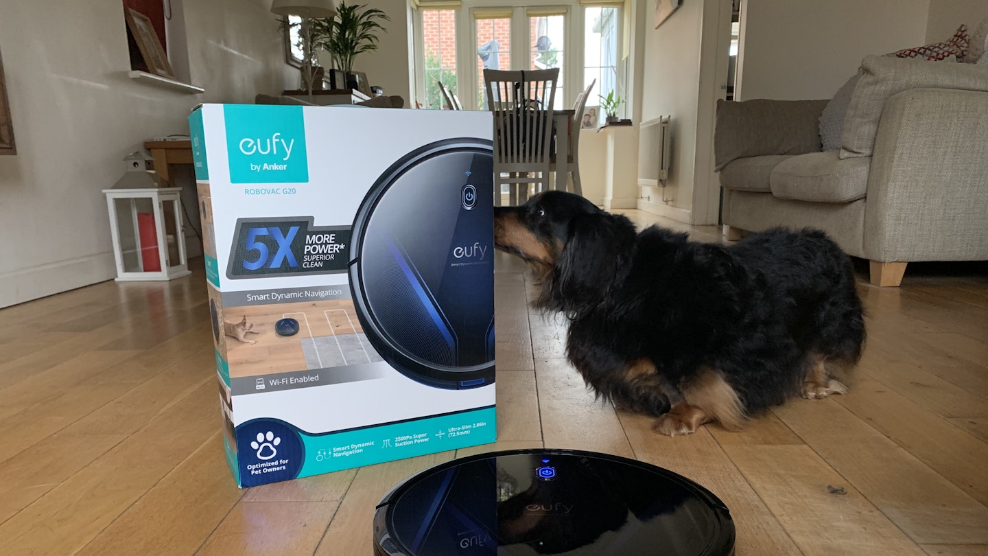 view of the G20 Robovac along with the original box and a dog.