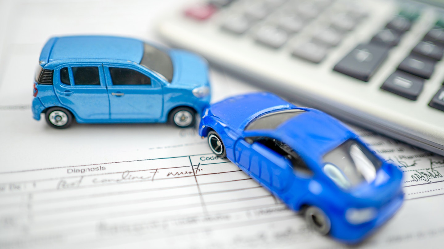 Toy cars sitting on an insurance form