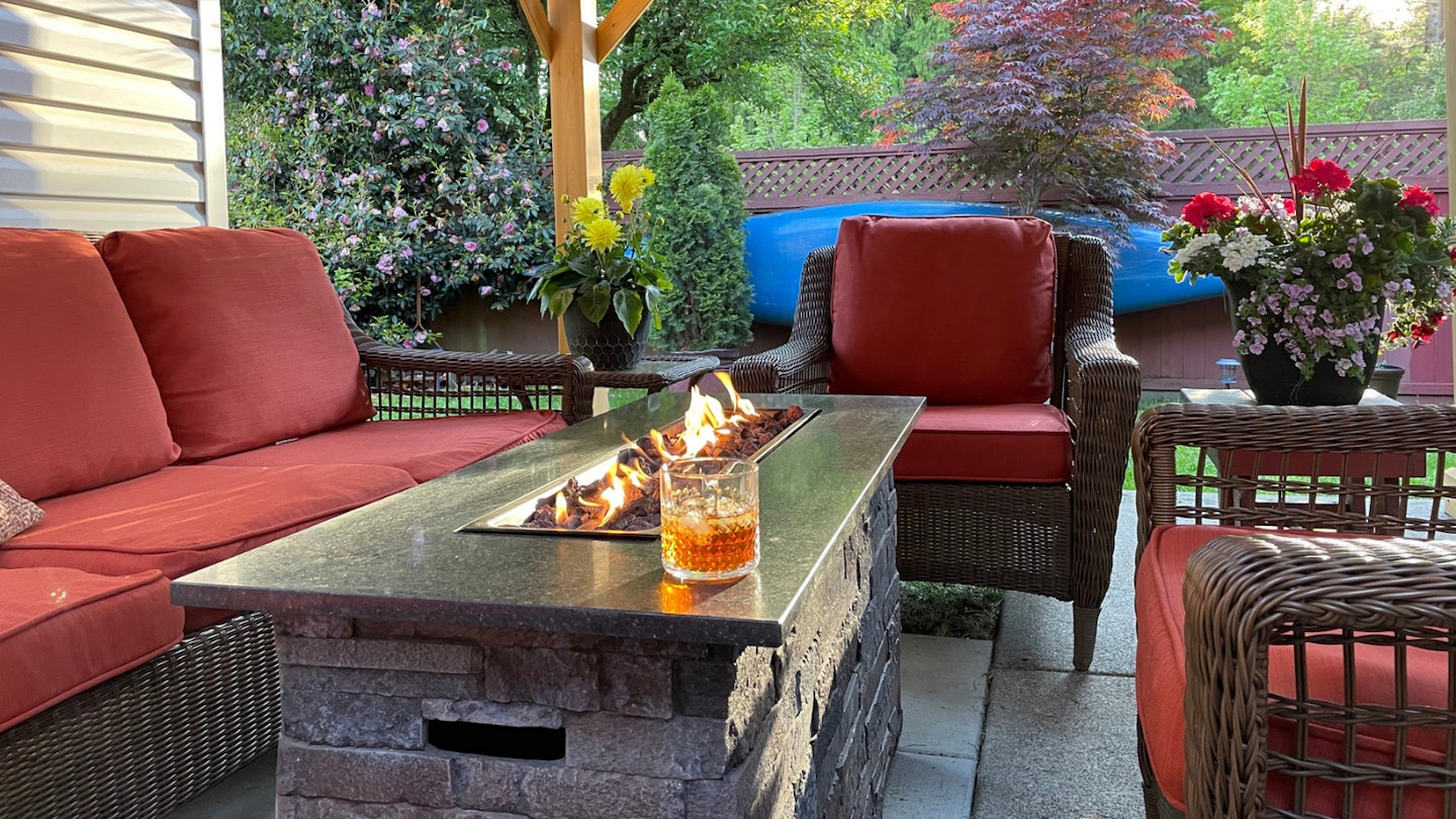 Fire pit coffee table on patio with drink on top