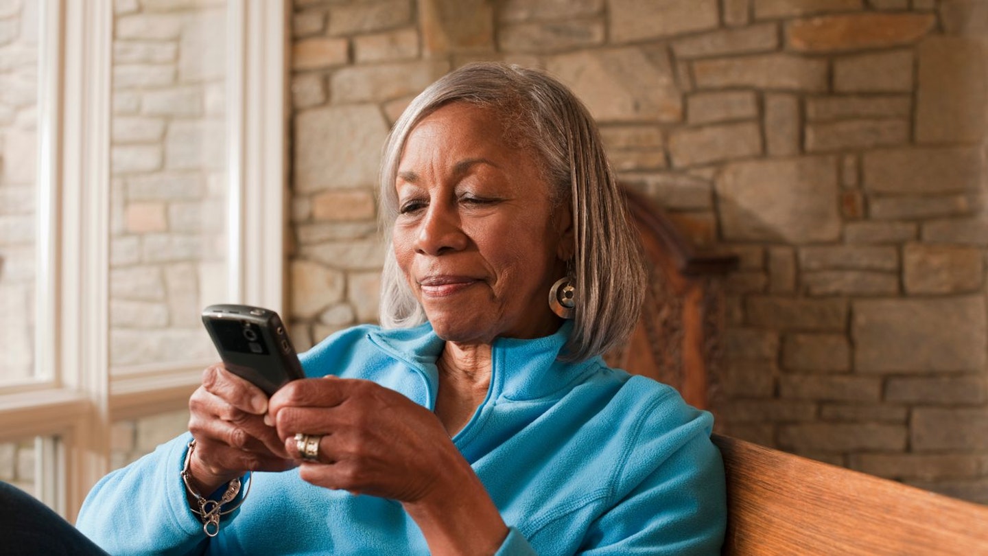 Woman smiling at her phone - the best mobile phones for older people