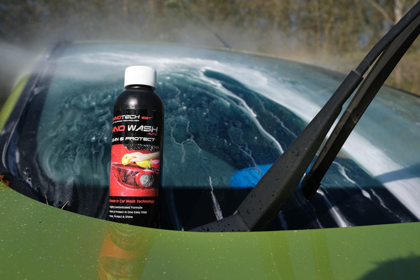 The Nano Wash bottle resting on a soapy windscreen