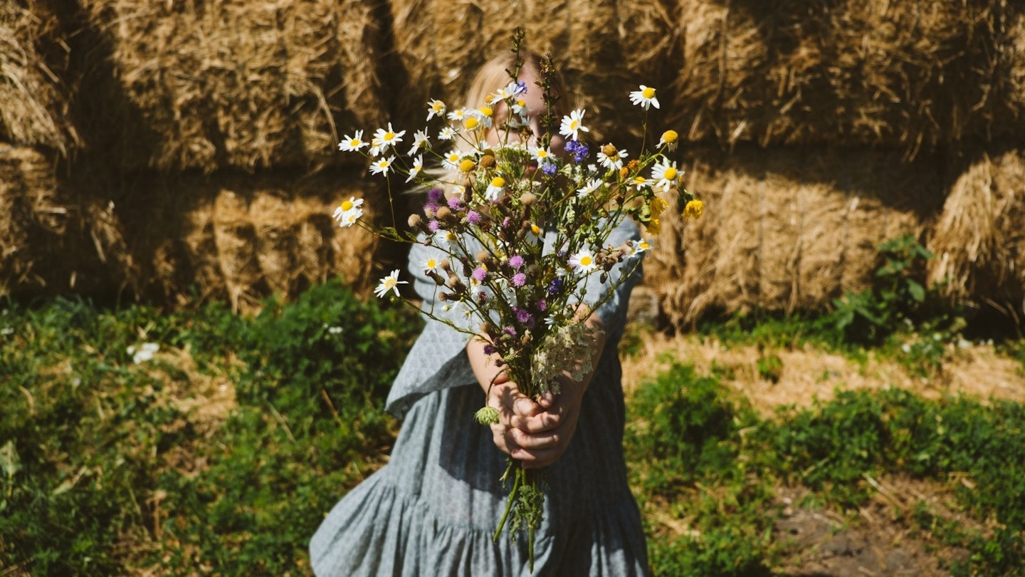 Cottagecore, Countryside aesthetics, Farming, Farmcore, Countrycore, slow life. Young girl in peasant dress and with flowers enjoying nature on country farm. Modern rural fantasy, pastoral aesthetic.