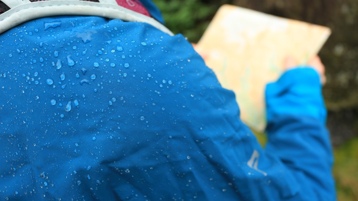 Water beading on a blue waterproof jacket