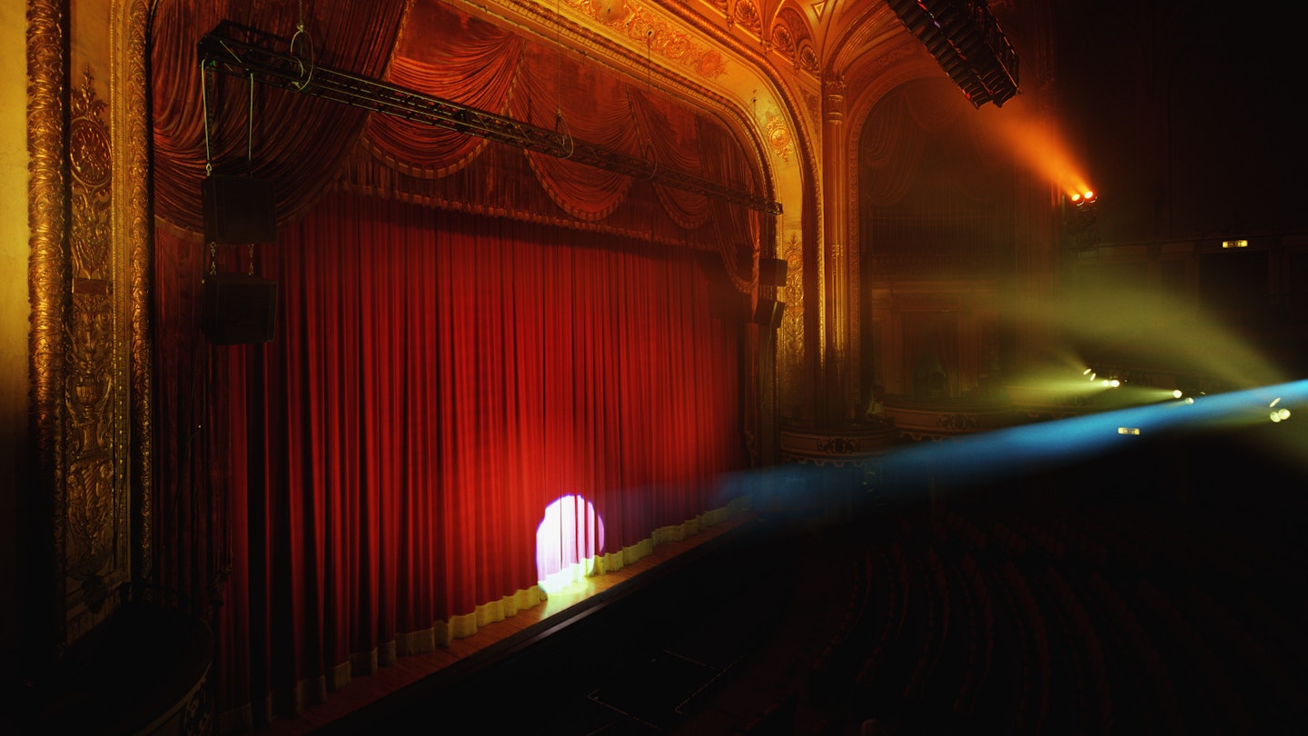 picture of theatre curtain with spotlight pointing centre stage