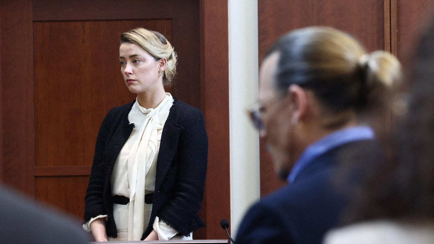Amber Heard testifies as Johnny Depp looks on during the defamation trial in Fairfax, Virginia