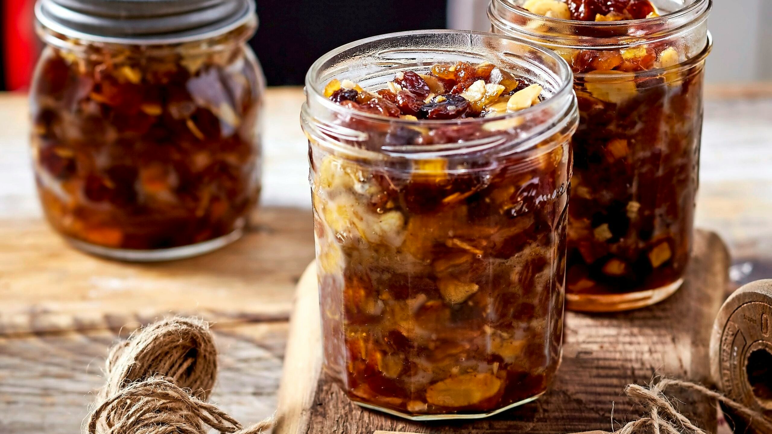 Homemade mincemeat in a jar set on a rustic table with a label.