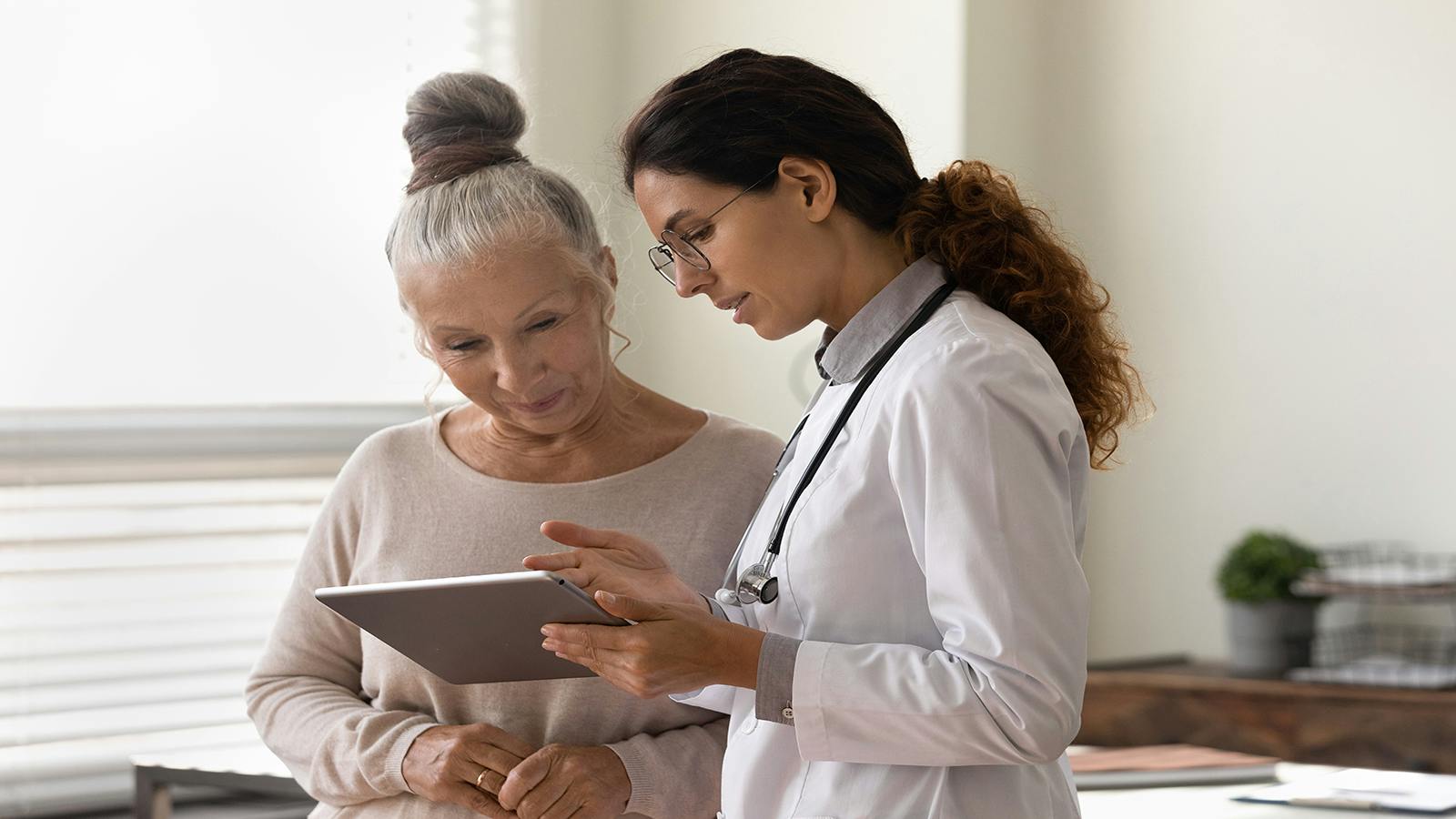 GP with patient and mobile tablet