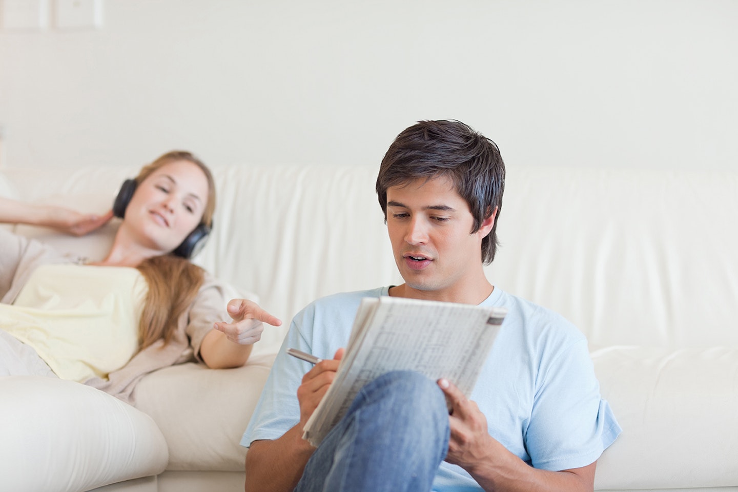 Woman helping man to solve crossword
