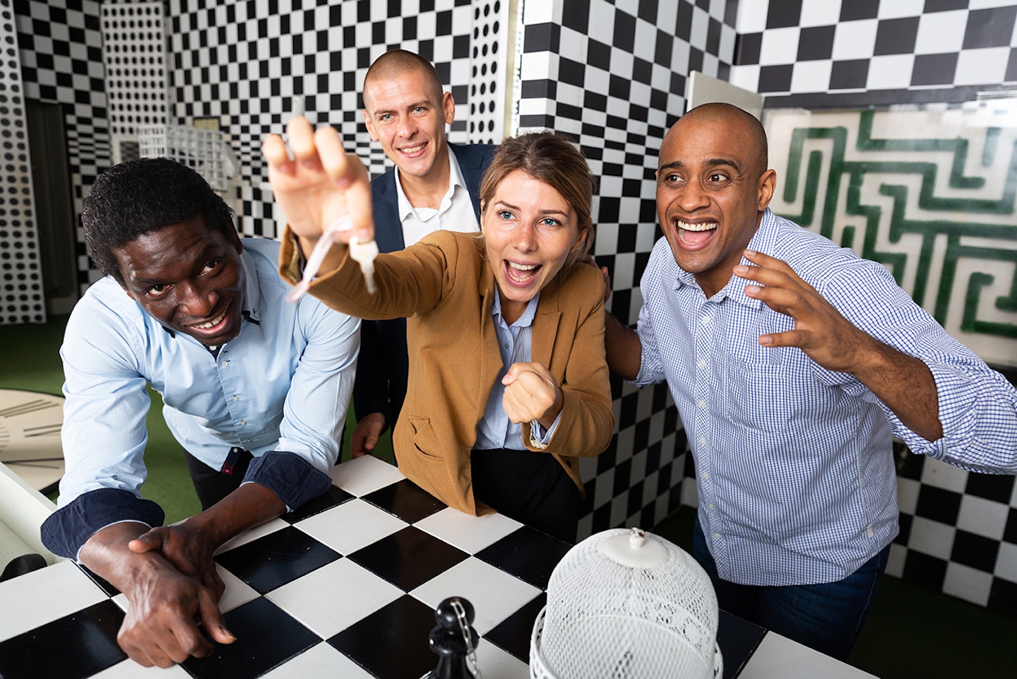 Four friends of different nationalities solving puzzles in quest room;