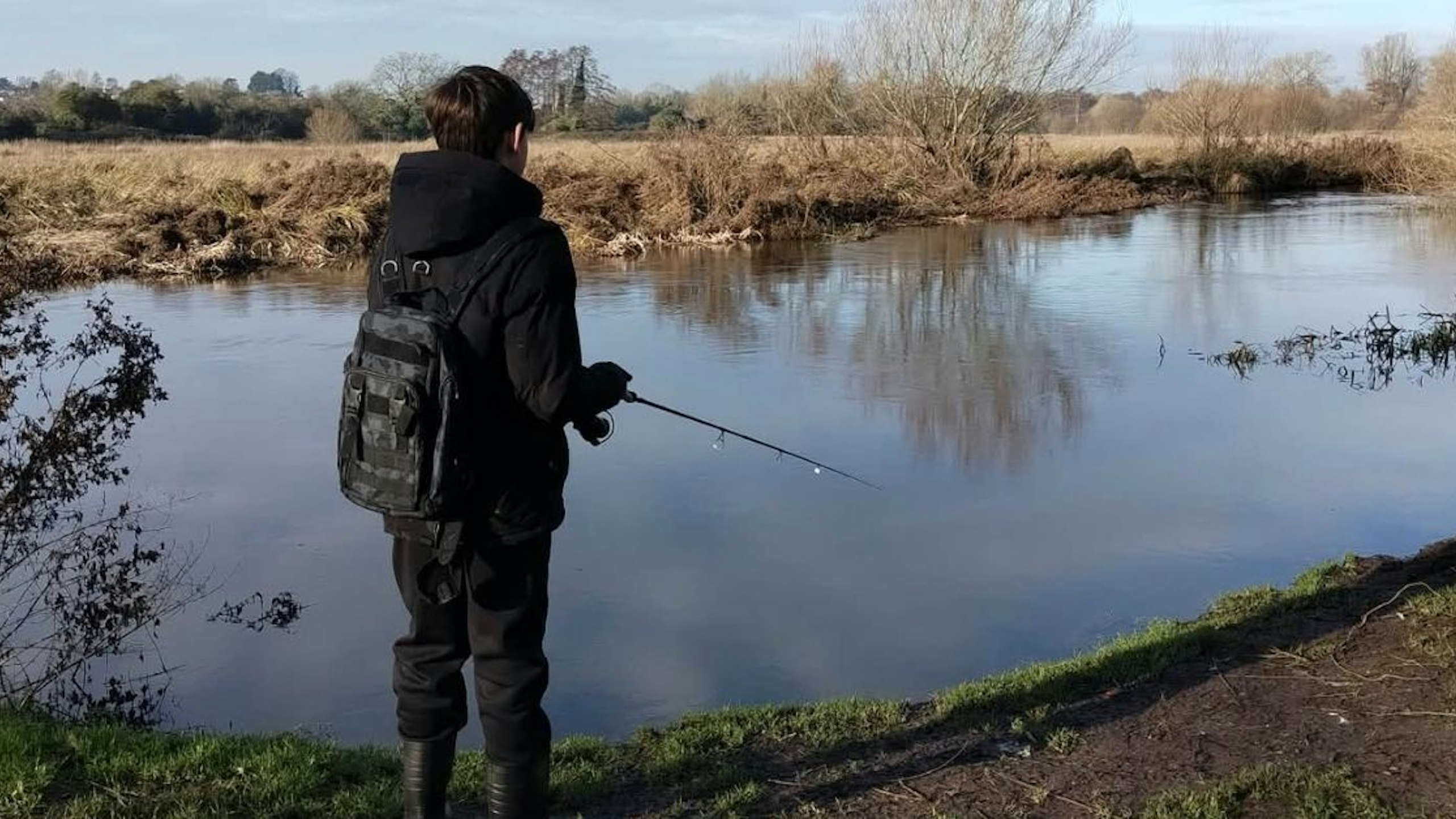 Person with autism enjoying a fishing session during an angling activity