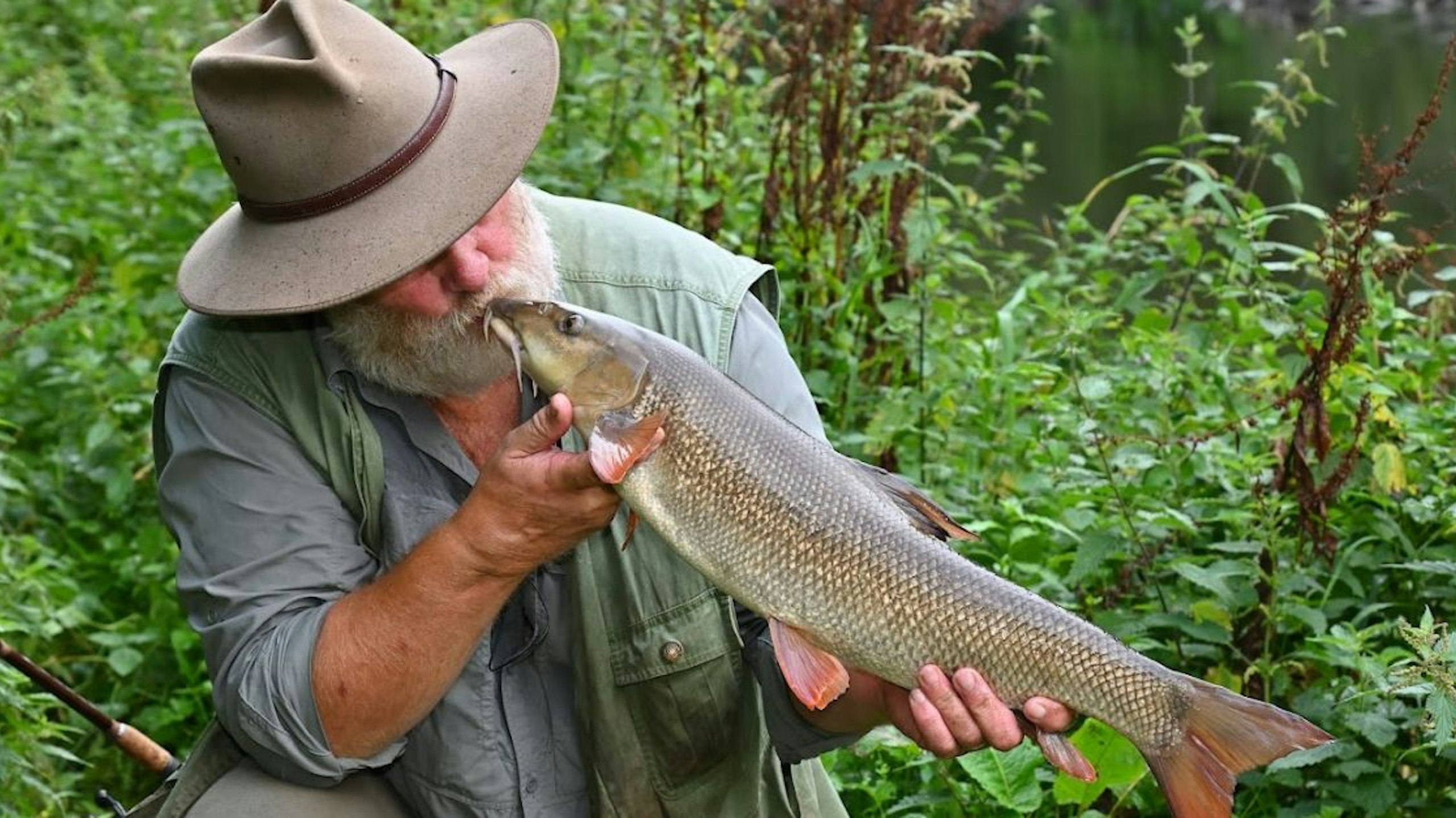 angler enjoying his catch by kissing it