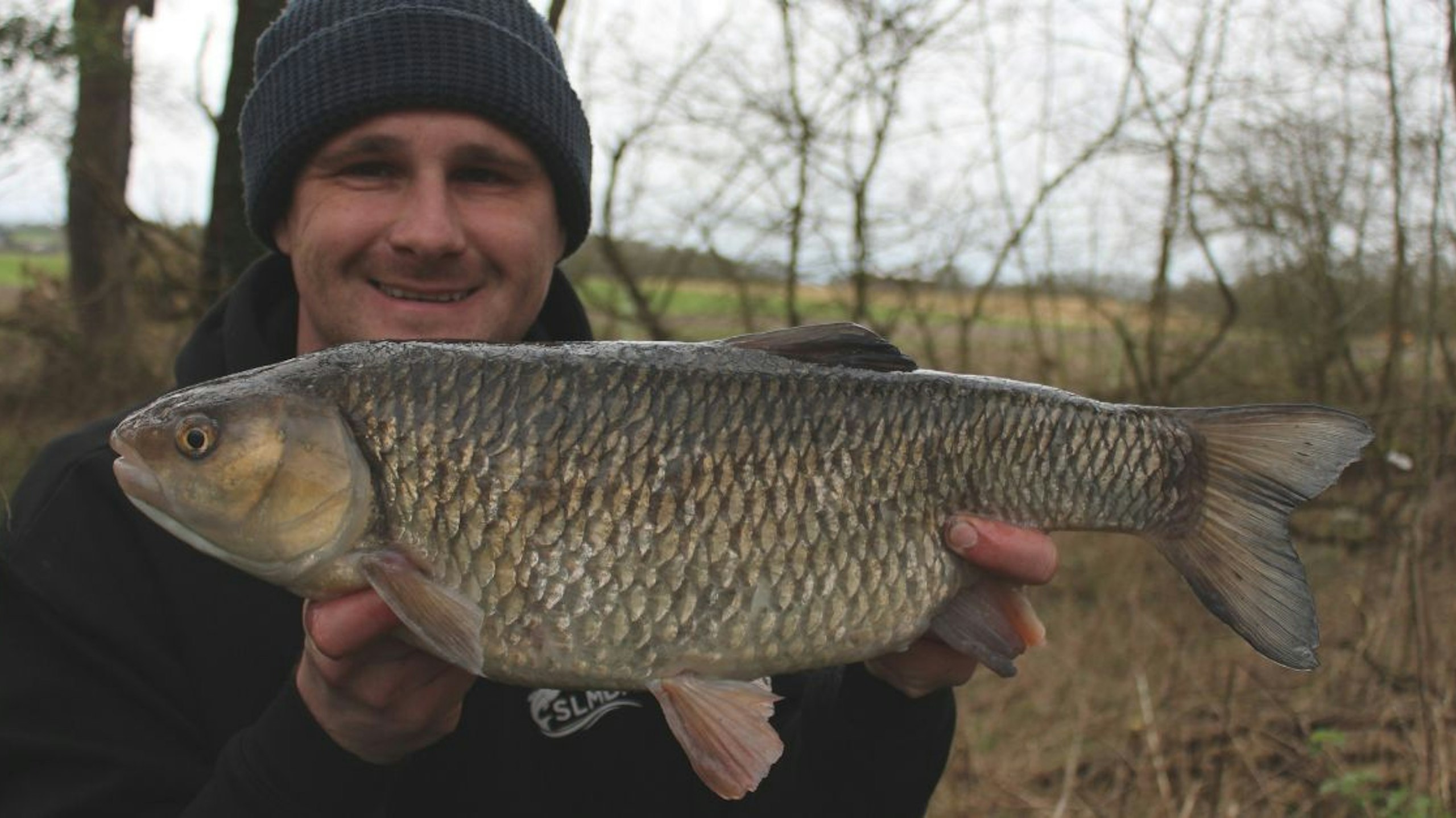 Angler holding big chub