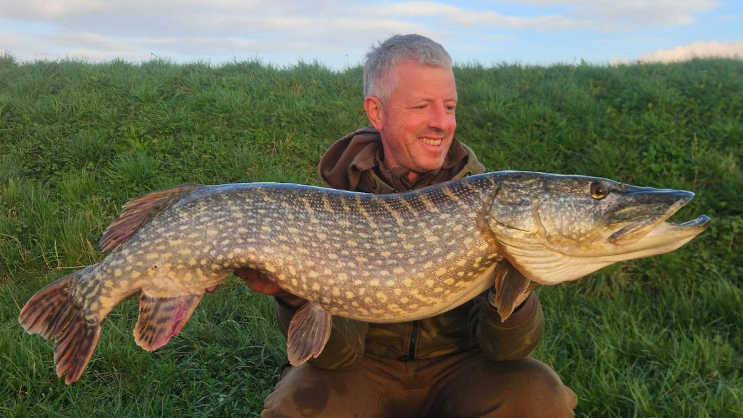 Ian Cousloon holding a hard-earned pike from the River