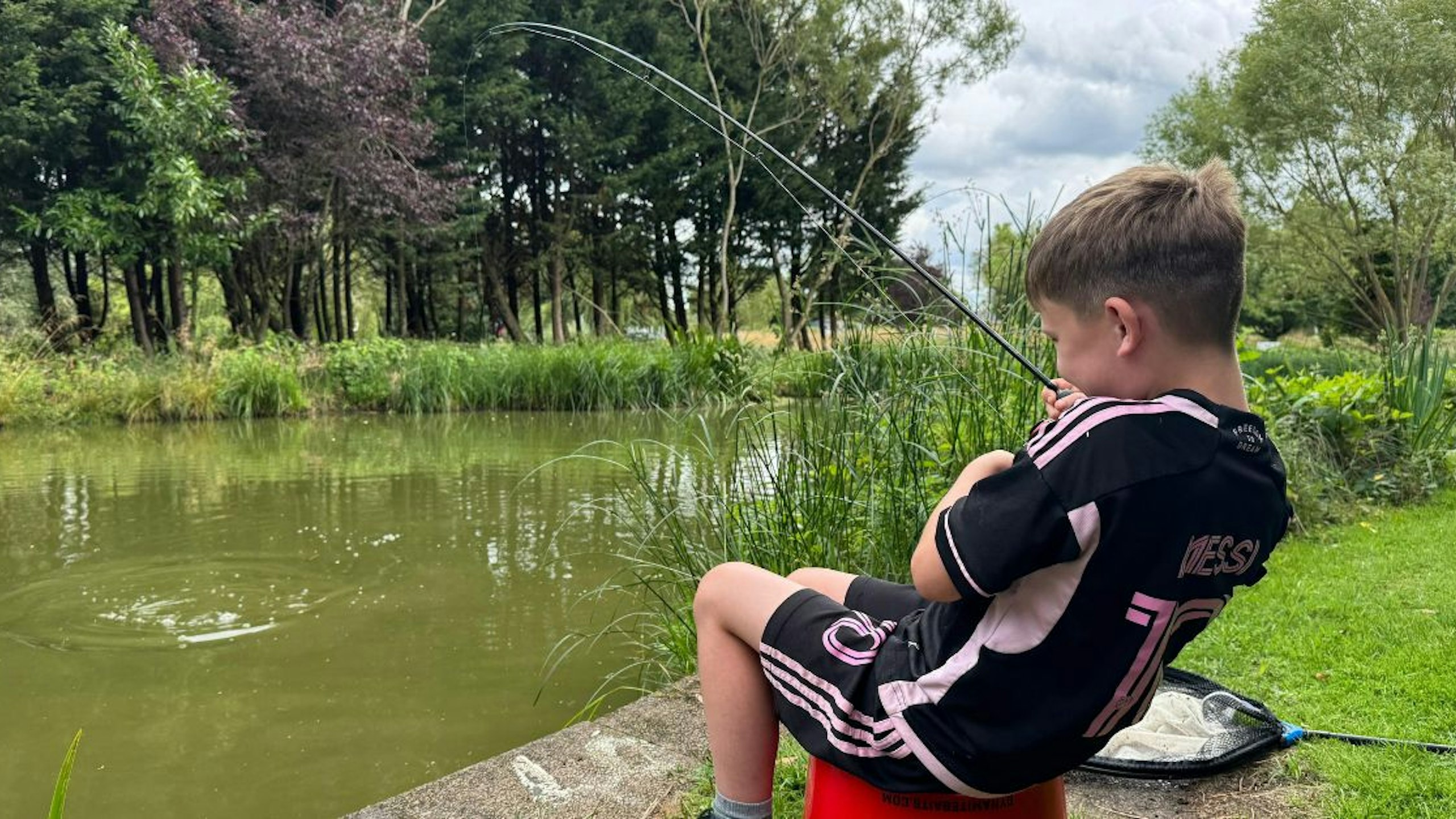 Young angler playing his first fish on rod and line