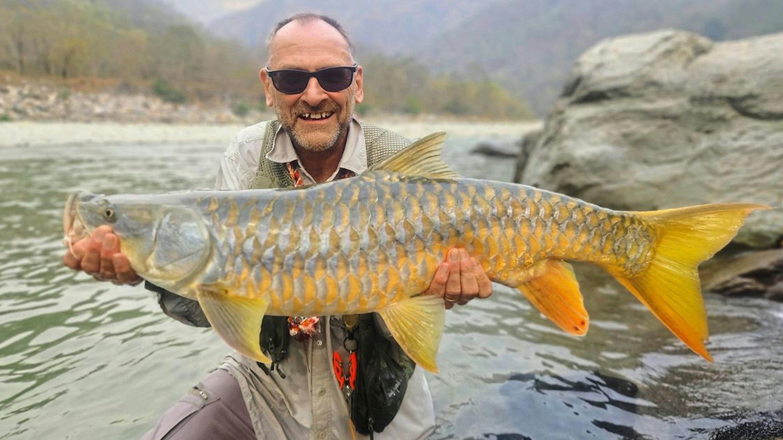 Anlger holding a rare and iconic mahseer