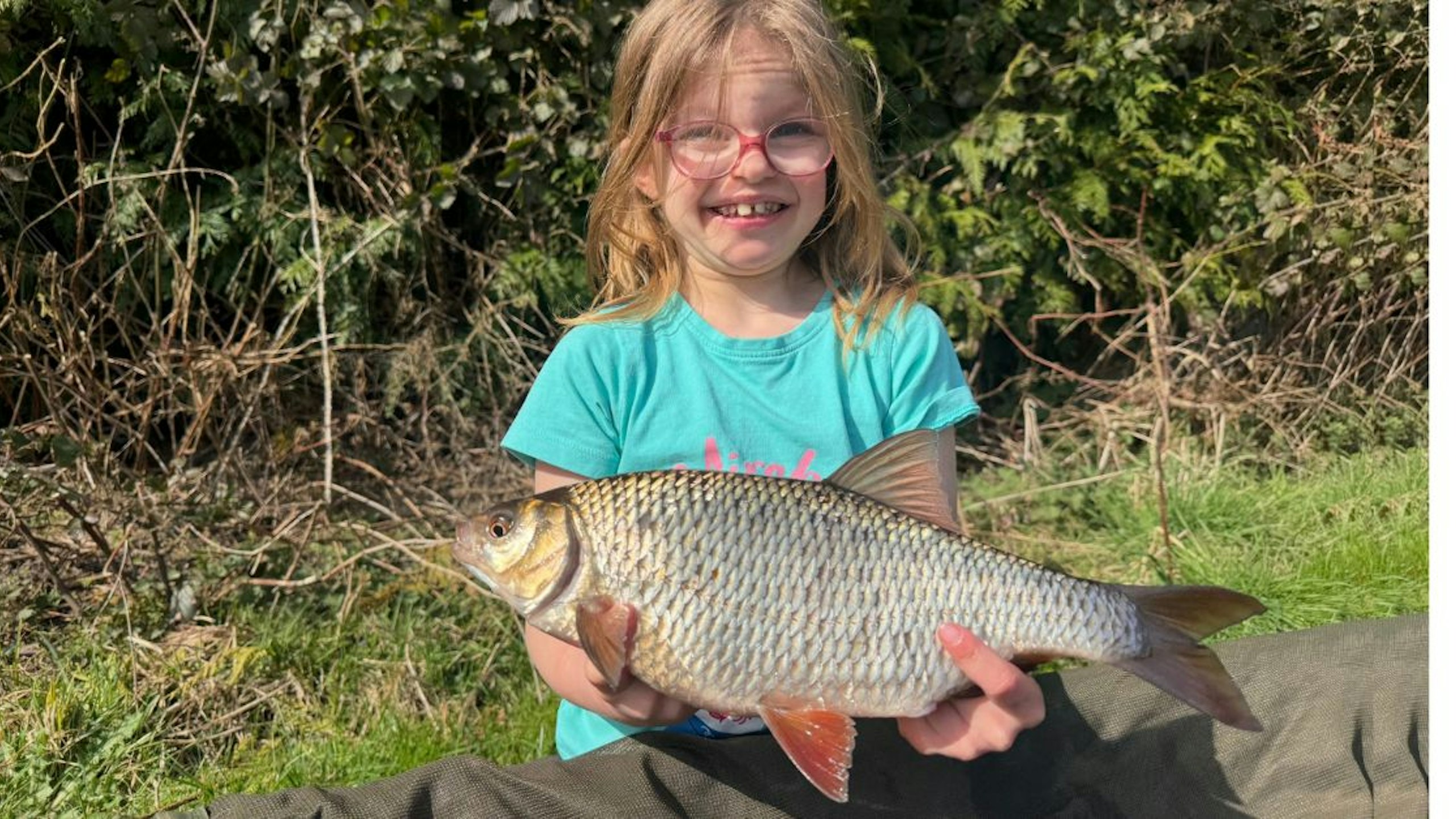 young female angler holding huge roach