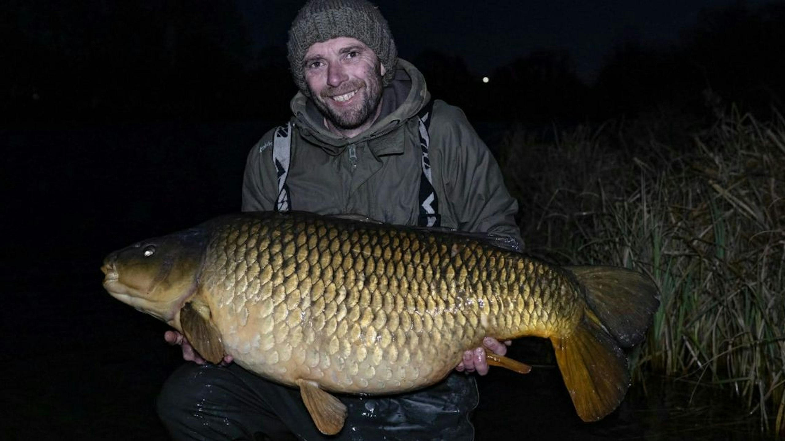 Angler cradling the UK's biggest common carp