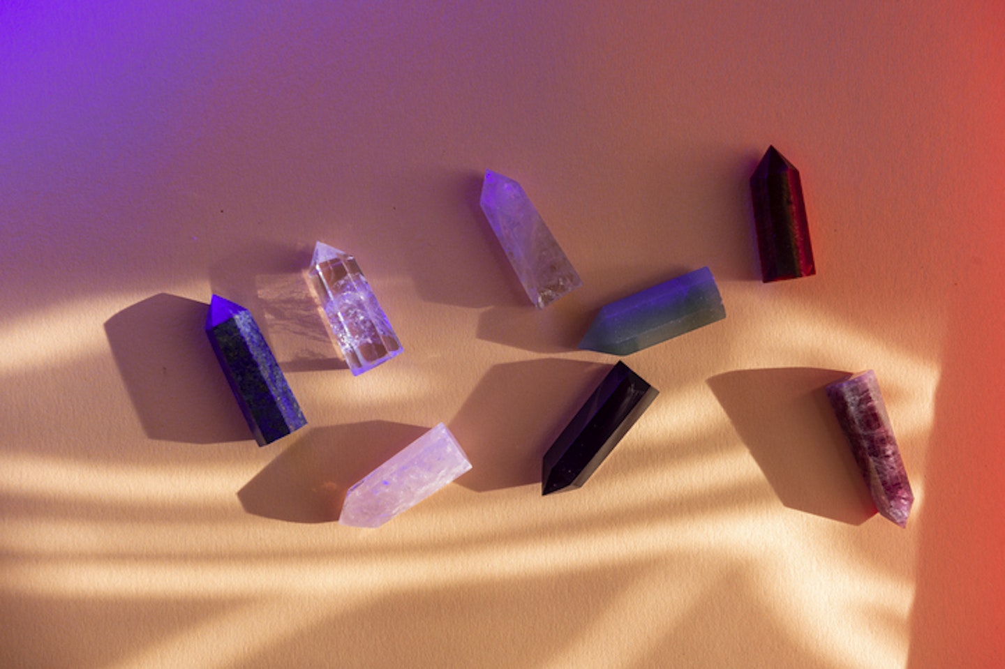 Healing chakra crystals with colorful light on beige background. Meditation, reiki and spiritual healing concept