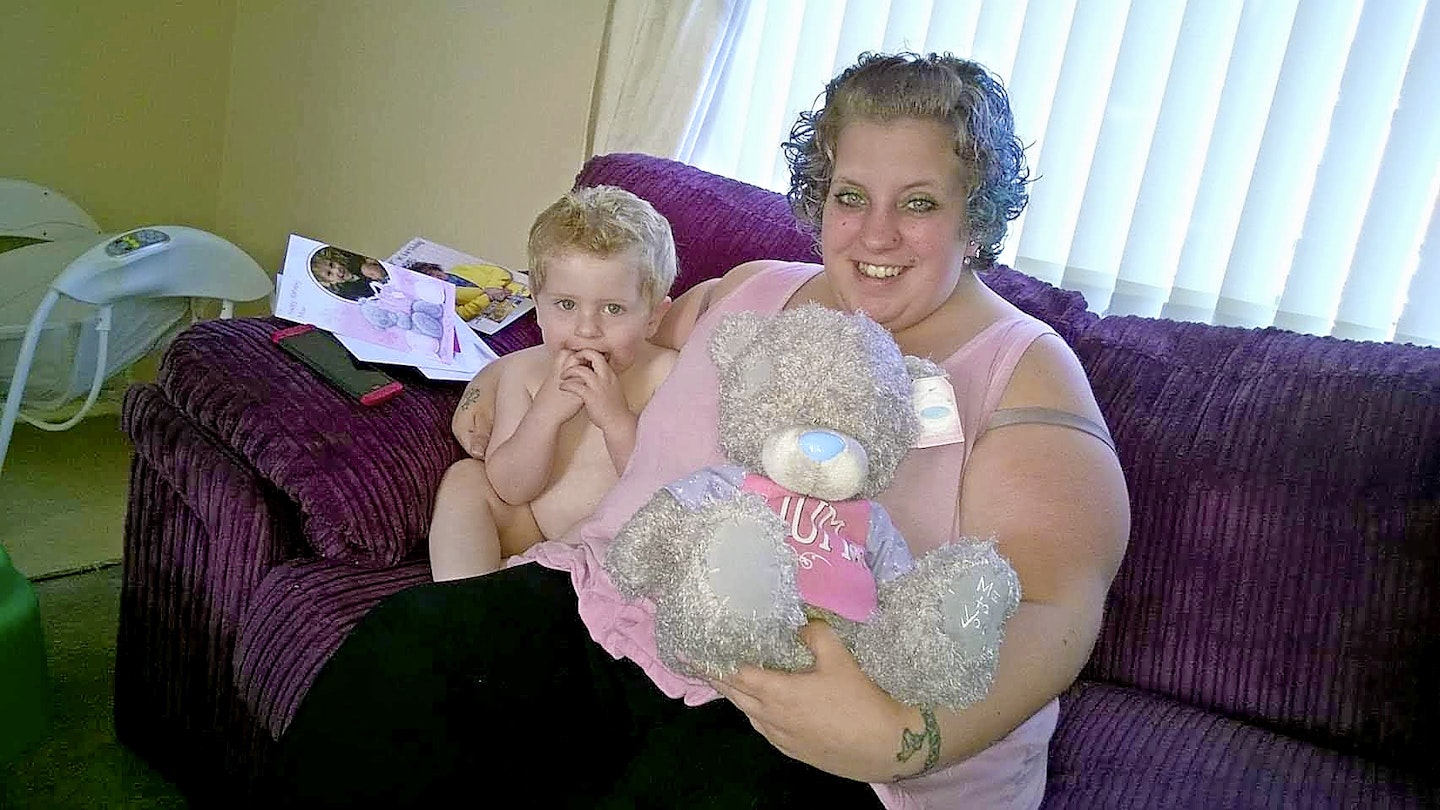 Woman on sofa holding cuddly toy