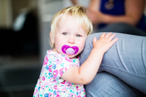baby holding mum's knee